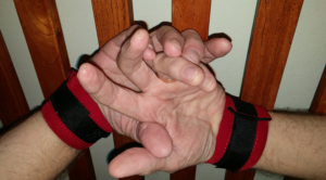 man's hands cuffed to headboard slats