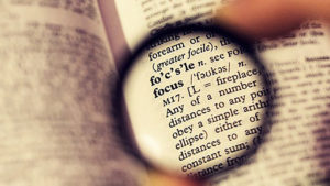 lens enlarging the word 'focus' in a dictionary