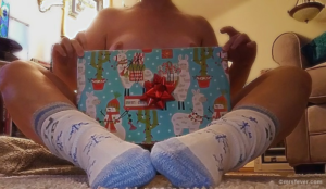 nude woman in Christmas socks holding llama-paper wrapped gift