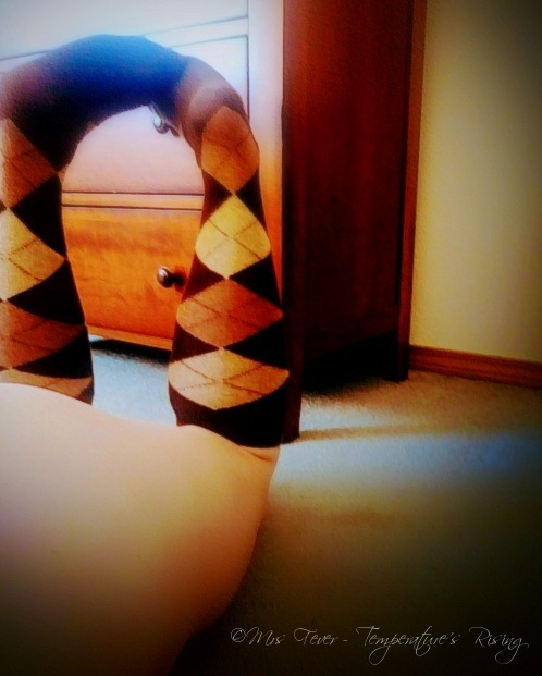 view of woman's legs, upturned laying face down, clad in argyle socks