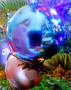 nude woman reflected in blue Christmas ornament