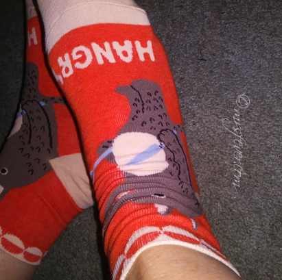 orange ankle socks that say HANGRY and have a picture of a cartoon wolf on them, holding a knife and fork