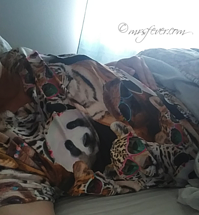 woman reclining on her side in bed wearing animal-themed pajamas