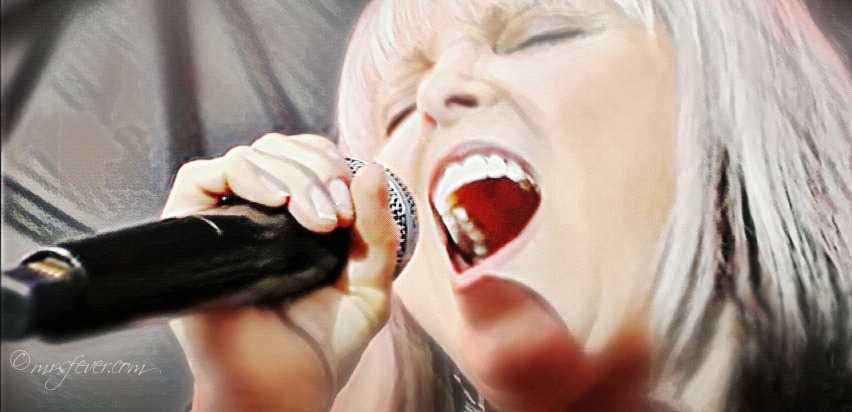 close-up of Pat Benatar singing into a microphone